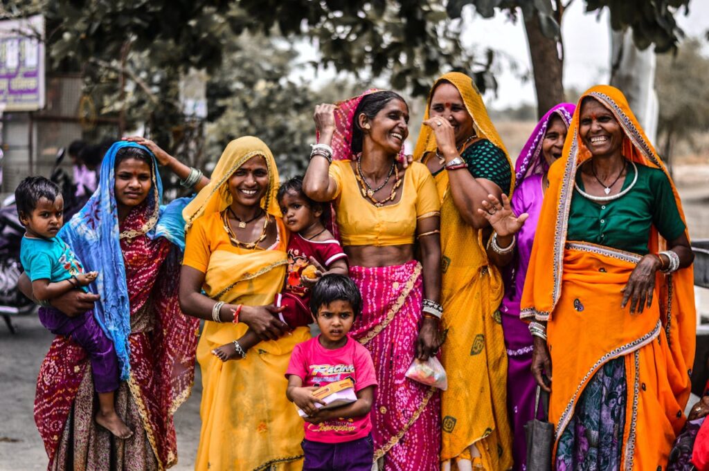 A lively group of women and children in traditional Rajasthani attire, showcasing vibrant culture and joyful expressions.